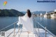 A woman in a white dress standing on a boat.