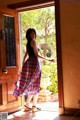 A woman standing in front of a wooden door.