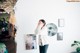 A woman standing in front of a wall with pictures on it.