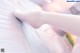A close up of a person's legs in white tights.