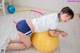 A woman sitting on an exercise ball with a hula hoop.