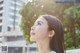 A woman looking up at the sky in front of a tall building.